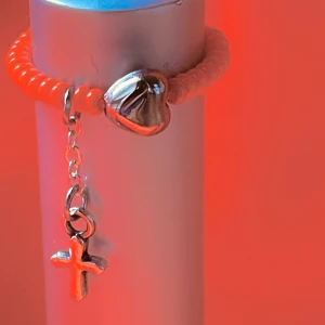By prisförslag- Orange ring små pärlor, hjärta och kors one size -  små pärlor och silverfärgade detaljer. Ringen har ett hängande kors och ett hjärta som ger en unik touch. Perfekt för att lägga till lite stil till din outfit.