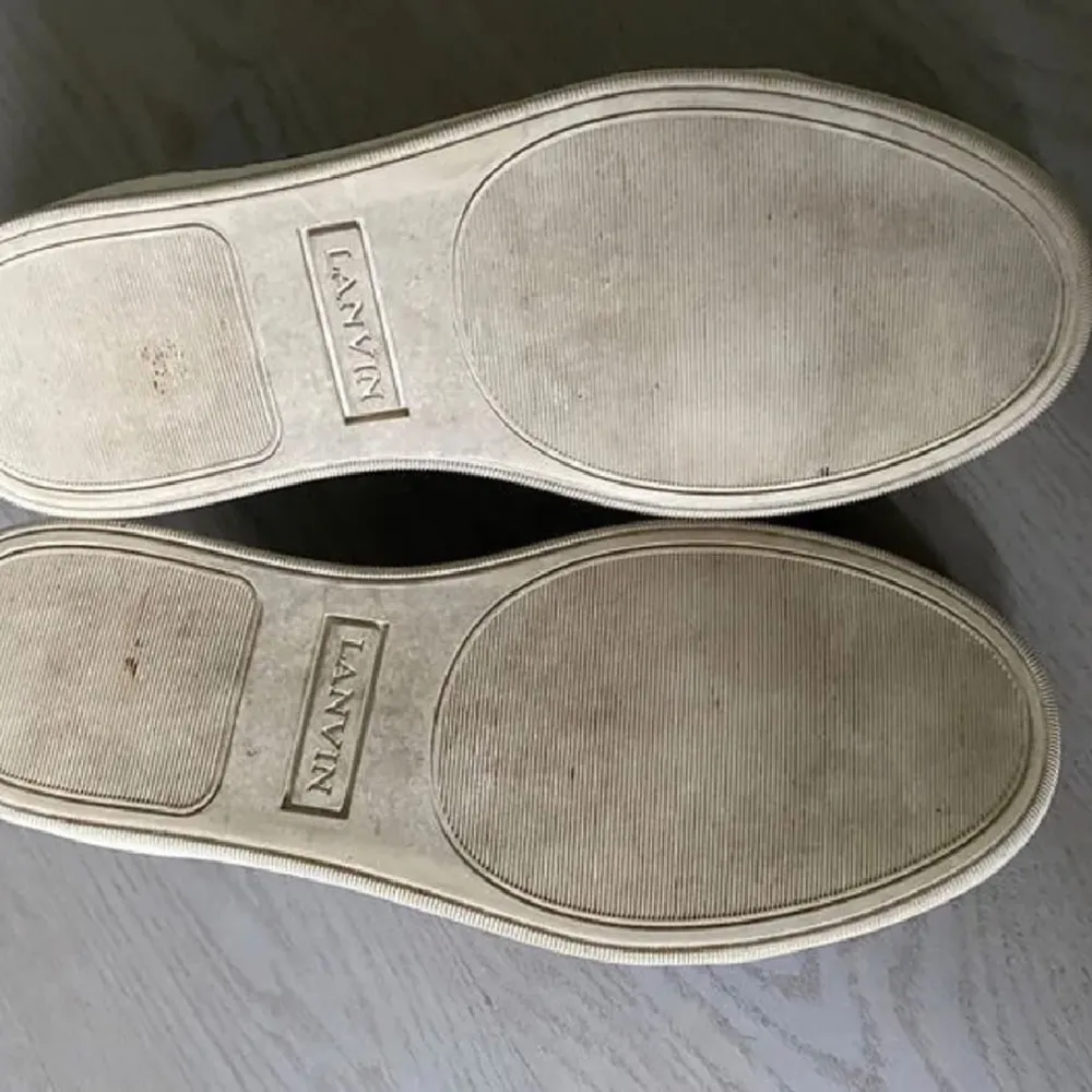 Säljer ett par svarta sneakers från Lanvin med vita, tjocka sulor och svarta skosnören. Skorna har en kombination av mocka och skinn, samt rund tå och diskret logga på insidan. Perfekta för en stilren och clean look, storlek 43. Kengät.