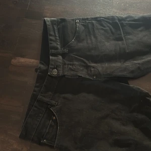 Svarta jeans från DSQUARED2 - Säljer ett par svarta jeans från DSQUARED2 i klassisk femficksmodell. Jeansen har raka ben, knappgylf och diskreta detaljer. Perfekta för dig som gillar stilrena och snygga byxor med premiumkänsla.