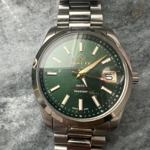 Gant klocka eastham   - Stilren herrklocka från GANT  grön färg, skön o använda passar bra också, priset diskuteras beror på hur seriös köparen är och om man köper snabbt