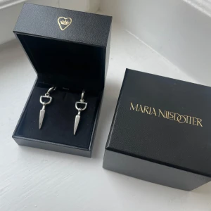 Silverfärgade örhängen från Maria Nilsdotter - Bitten earrings från Maria Nilsdotter. Säljer endast som par och byter inte. Använda vid några enstaka tillfällen. Nypris: 4600kr