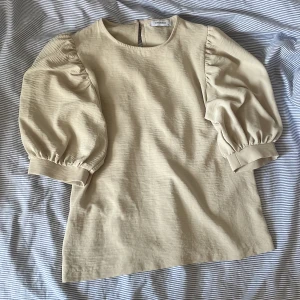Beige topp från Chiquelle - Säljer en stilren beige topp från Chiquelle med puffiga trekvartsärmar ❤️Den är i jättefint skick säljer då den är lite för stor! (Pris kan diskuteras)