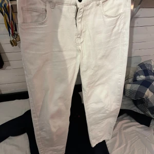 Vita jeansbyxor - Snygga vita jeansbyxor från Studio Total med normal passform och klassisk femficksdesign. Perfekta för en stilren look. De har en knapp och dragkedja framtill.