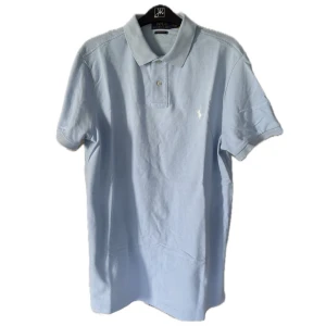 Polo Ralph Lauren Piké - Säljer en babyblå piké från Polo Ralph Lauren som är i jätte bra skick, enkel att matcha och väldigt unik. Modellen är i slim fit. Priset kan diskuteras!