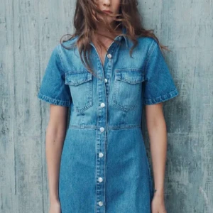 Jeansklänning med knappar - Snygg jeansklänning i blå denim med korta ärmar och knappar framtill. Två bröstfickor med lock ger en cool touch. Perfekt för en avslappnad stil.