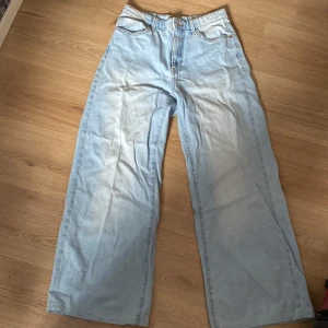 Ljusblå wide leg jeans från Lindex - Ljusblå jeans från Lindex i modellen Jackie. Byxorna har en bred, rak passform med hög midja och klassiska fickor både fram och bak. Perfekta för en avslappnad och trendig look.