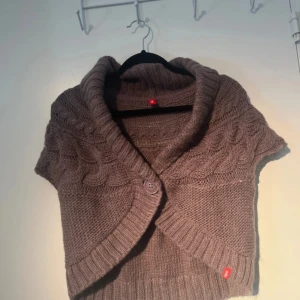 Brun stickad bolerotopp från edc - Säljer en mysig brun stickad bolerotopp från edc. Den har en stor krage och korta ärmar med flätstickat mönster. Perfekt för lager-på-lager-stil. Köp direkt eller ge prisförslag!