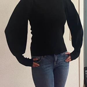 Svart tröja med puffärmar - Säljer en stilren svart tröja med puffiga långa ärmar. Perfekt för en elegant look. Tröjan har en normal passform och är tillverkad i ett mjukt material. Använts ett par gånger men nytvättad, från NAKD. Pris kan alltid diskuteras.
