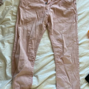 Rosa jeans från please - Säljer ett par snygga rosa byxor från please. Byxorna har en normal passform och de har praktiska fickor och en fin hjärtformad detalj vid bakfickan. Perfekta för en avslappnad stil!