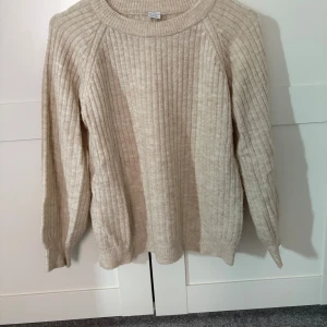 Beige ribbad tröja från Lindex - Säljer en mysig beige ribbad tröja från Lindex. Tröjan har långa ärmar och en rund halsringning, perfekt för kyligare dagar. Passar bra till både jeans och kjol. Perfekt för barn som gillar stil och komfort. Är som en xs