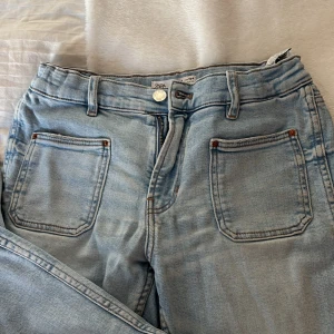 Ljusblå jeans från Zara - Snygga ljusblå jeans från Zara i storlek 13-14 år. De har en klassisk femficksdesign med dragkedja och knapp framtill. Perfekta för en avslappnad stil. Bootcut