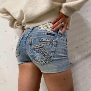 Blå jeansshorts från Miss Me - Snygga blå jeansshorts från Miss Me. ‼️trotts storlek kan den passa folk med 25-26‼️. Shortsen har en tajt låg midjad passform. Shortsen har en minimal röd missfärgning😊