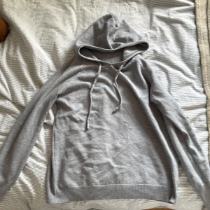 Grå merino hoodie - Säljer en grå merino hoodie med långa ärmar och justerbar huva. Perfekt för en avslappnad look. Passar bra till både jeans och joggers. Hör av er vid frågor eller funderingar 