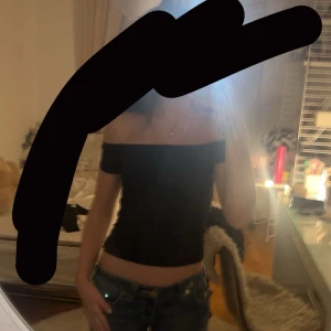 Svart offshoulder topp - Snygg svart offshoulder topp som är perfekt för en stilren look. Toppen är ribbad och har en tight passform som framhäver figuren. Perfekt för att matcha med jeans eller kjol för en kväll ute.