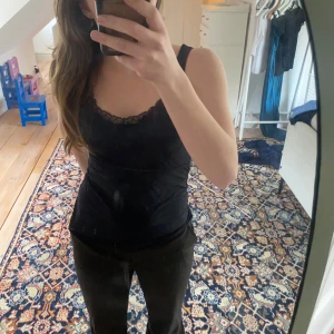 Svart linne med spetsdetaljer - Snyggt svart linne med spetsdetaljer vid halsringningen.