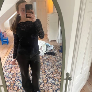 Svart spetsblus - Säljer en elegant svart spetsblus med långa ärmar.