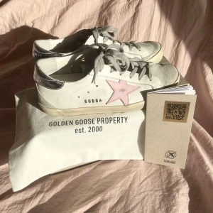 Golden Goose sneakers - Golden Goose sneakers i vitt med en rosa stjärna på sidan. Grå snörning och svart sula. Använts två gånger och är i princip ny skick. Extremt bekväma skor och true to size. Skorna är köpta för 5600kr. Pris går att diskutera vid snabba affärer. 