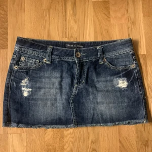 Jeanskjol från House of Denim - Snygg jeanskjol från House of Denim med slitna detaljer, perfekt till sommaren! Midjemåttet rakt över är 40 cm!💗