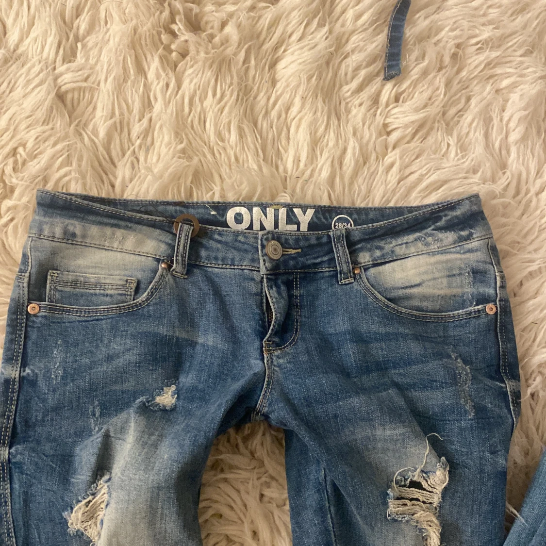 Lågmidjade blå bootcut jeans med slitningar  - 1