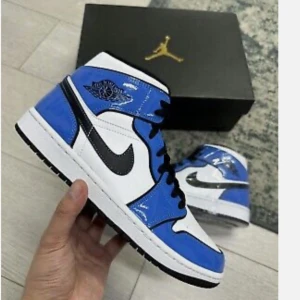 Nike Air Jordans ”Signal Blue” - Snygga Nike Air Jordans i en fräsch blå och vit färgkombination. Skorna har en klassisk design med svart swoosh och snörning. Perfekta för att ge din outfit en sportig touch. 