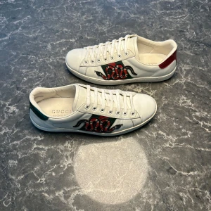 Gucci Ace Snake - Säljer ett par otroligt snygga skor från det exklusiva italienska märket Gucci! Skorna är i otroligt bra skick, skulle säga ungefär 9/10. Nypris ligger på över 9000kronor men vi säljer våra för endast 2399 och kan gå ner i pris ännu mer vid snabb affär! Skorna är 40,5 i storlek men stora. Skriv gärna ifall det är några funderingar, allt bästa SkoKapet