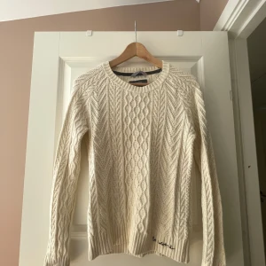 Vit stickad tröja med kabelmönster - Säljer en vit stickad tröja från Bondelid med snyggt kabelstickat mönster. Tröjan har rund halsringning, långa ärmar och ribbade muddar. 