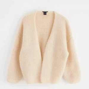 Beige fluffig kofta från & Other Stories - Supermjuk och oversized beige kofta från hm. Koftan har en öppen front, lång ärm och är gjord i ett fluffigt stickat material som känns lyxigt och mysigt. Perfekt att slänga på sig när du vill vara både chill och snygg.