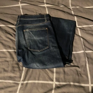 Acne Studios Max Prince jeans blå - Snygga blå jeans från Acne Studios, modell Max Prince. Klassisk femficksdesign med gul kontrastsöm och raka ben. Jeansen är tillverkade i bomull med lite stretch för extra komfort. Perfekta för dig som gillar stilrena och tidlösa jeans.