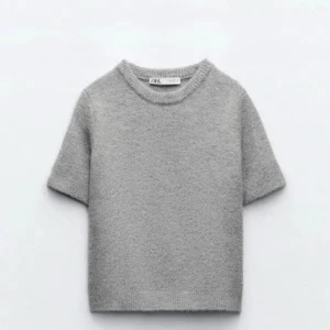 Grå stickad kortärmad tröja Zara - Supermjuk grå stickad tröja från Zara med korta ärmar och rund halsringning. Enkel och clean design som passar perfekt till jeans eller kjol. Tröjan har en rak passform och är gjord i ett mysigt stickat material. Använd fåtal gånger, som i nyskick. 