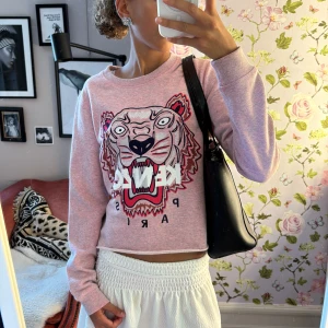 Rosa Kenzo  - Superfin rosa sweatshirt från Kenzo med ikoniskt tigertryck och broderad logga på bröstet. Tröjan har en croppad passform, rund hals och långa ärmar. Perfekt statement piece för dig som vill sticka ut med cool design och snygga detaljer. Passar mig som har xs