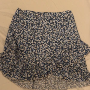 Blå blommig volangkjol med dragkedja - blå kjol med dragkedja