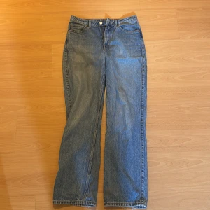 Weekday ljusblå raka jeans - Klassiska weekday jeans i ljusblå tvätt med raka ben och femficksmodell. Jeansen har normal passform, knappgylf och tydliga slitningar för en vintagekänsla. Perfekta för dig som gillar en avslappnad och tidlös denimstil.