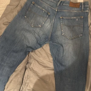 Tiger of Sweden jeans - Tiger of Sweden jeans  i ljusblå tvätt med raka ben och femficksmodell. Jeansen har en snygg vintagekänsla. 31/34