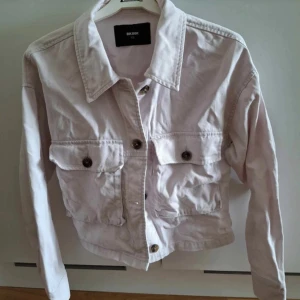 Ljusrosa jeansjacka från Bik Bok XS - Snygg ljusrosa jeansjacka från Bik Bok i storlek XS.                                                                      Jackan har klassisk krage, två stora bröstfickor med knappar och långa ärmar.                     Perfekt att slänga över en hoodie eller t-shirt för en chill look.