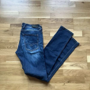 Replay Anbass hyperflex jeans  - Säljer ett par mörkblå Replay Anbass hyperflex jeans med snygg tvätt och klassiska fem fickor. Jeansen har raka ben, normal passform och är tillverkade i mjukt bomullsjeansmaterial. Snygga kontrastsömmar och diskret Replay-logga på bakfickan. Midja ca 40cm