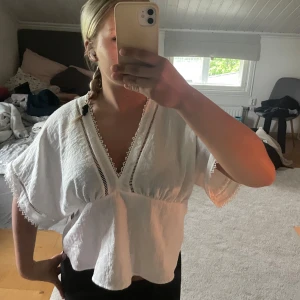 Vit blus från Zara - Superfin vit blus från Zara med v-ringning och spetsdetaljer längs kanterna. Fint skick och sparsamt använd💕passar även s