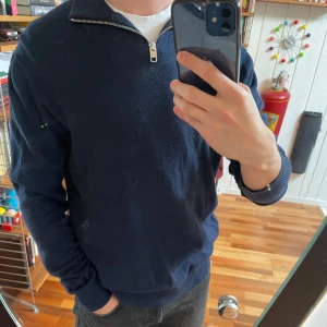 Mörkblå halfzip  - En lite tunnare mörkblå stickad tröja med half zip-dragkedja i halsen. Väldigt bra för lager-på-lager och chill stil. Enkel och stilren design utan några synliga loggor. 