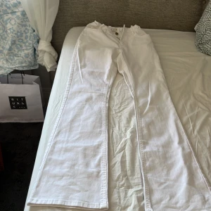 Vita wide jeans  mid  - Har aldrig andvänt. Säljer ett par vita jeans från Anine Bing med medel midja och breda ben. Byxorna har klassiska bakfickor och stängs med knapp och dragkedja. Perfekta för en clean och trendig look.
