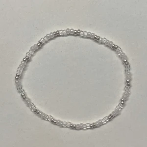 Pärlarmband med silver- och glaspärlor - Hemgjort armband med små genomskinliga, vita och silvriga pärlor. Gjord med en elastisk tråd och kan även göras i andra storlekar och färger💞💞 Väldigt gullig accessoar!                     Obs! -silverpärlorna kan tappa sin färg om de tvättas mycket i vattnet.