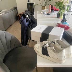 Valentino vita sneakers med nitar - Snygga vita sneakers från Valentino med svart detalj och coola nitar på sidorna. Skickar självklart dessa skor helt nytvättade, samt boxen följer med 🫶🏻 