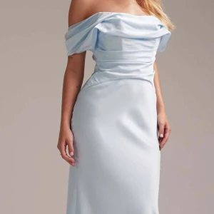 Ljusblå offshoulder långklänning - Säljer min otroligt fina balklänning i ljusblått, satinliknande material. Modellen är off-shoulder med en vacker draperad överdel. Den är endast använd en kväll och har några små smutsfläckar som enkelt går bort i tvätten ☺️ Inga synliga defekter i övrigt. Jag är 169 cm lång och klänningen sitter perfekt på mig.  Nypris: 1709 kr. Skicka gärna ett meddelande om du vill se fler bilder – och priset kan självklart diskuteras 💞💞