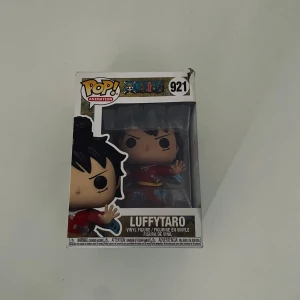 Luffytaro Funko-pop - Upptäck Luffytaro från One Piece som cool Funko Pop! Vinylfigur. Perfekt för fans av manga och anime, denna samlarfigur ger din hylla extra karaktär och action!