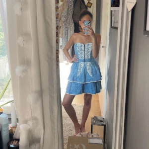 Denim klänning med spetsdetaljer - Säljer min denim klänning med vita spetsdetaljer och volanger då den inte längre kommer till användning. Klänningen är i storlek 34 men passar både Xs och S. den är bara använd 2-3 gånger så nästan helt oanvänd! Skriv för flera bilder!🫶🏽