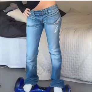 disel jeans - Säljer ett par blå bootcut jeans med slitna detaljer och dubbla knappar i midjan. midjemått: 36 innerben: 80 