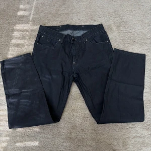 Svarta jeansbyxor från JC - Svarta jeansbyxor från JC med klassisk femficksdesign och raka ben. Byxorna har normal passform och stängs med dragkedja och knapp. Perfekta för dig som gillar en enkel och stilren look.