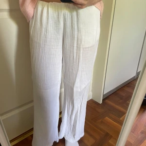 Vita linnebyxor från Gina Tricot - Säljer ett par vita, luftiga linnebyxor från Gina Tricot i storlek S. Byxorna har snörning i midjan samt raka, vida ben. Perfekta för varma dagar och har en avslappnad passform. Använda ett fåtal gånger, säljer då jag har flera par linnebyxor och dessa är lite för långa för mig (som är 160cm) men de går såklart att vika in i midjan.