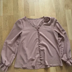 Brun blus  - En fin brun blus i strl M. På bilderna ser blusen ut att vara mer rosa än vad det är IRL (mer åt brun hållet). Köpt second hand men är för stor därav försäljning. 
