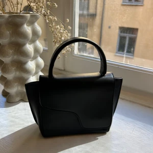 Apt väska - Säljer en svart handväska från apt! Den är i lilla modellen! Bandet tappa jag i Spanien men går att köpa nytt. Hör av er vid eventuella frågor!💗