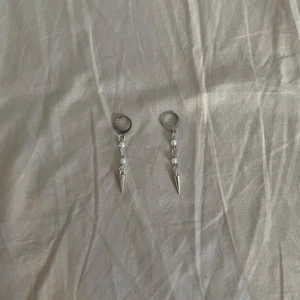 ”Amelia” örhängen  - Säljer ett par coola silvriga örhängen med små pärlor och spetsiga detaljer. Perfekta nu till sommaren💘💘Gjorda av rostfritt stål!!