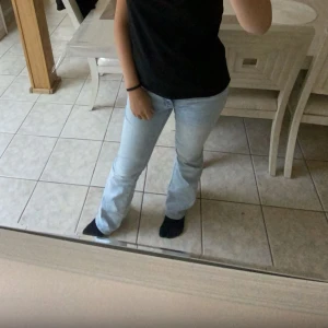 Ljusblå bootcut jeans - Säljer ett par ljusblå jeans med bootcut passform. Jeansen har klassisk femficksdesign och är tillverkade i denim. Perfekta för dig som gillar en avslappnad men ändå stilren look.